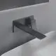 Wand-Waschtischarmatur in Magnetic Grey von Ideal Standard, mit eckiger Rosette und einem langen, geraden Auslauf, montiert an einer hellen Wand und über einem weißen Waschbecken.
